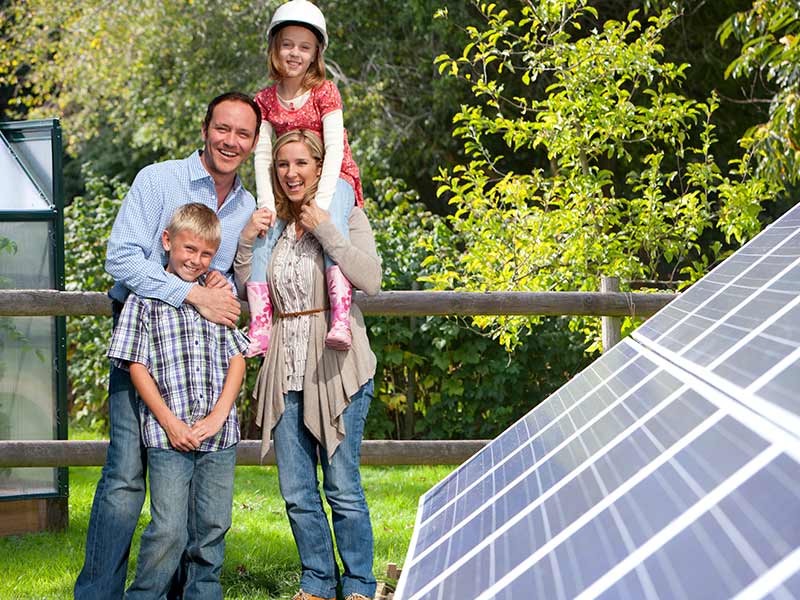 What equipment do I get in a solar panel kit? happy family standing next to solar panels