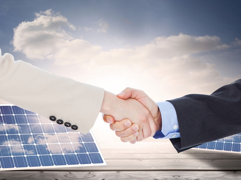 Solar loans not secured against your home shaking hands over solar panels