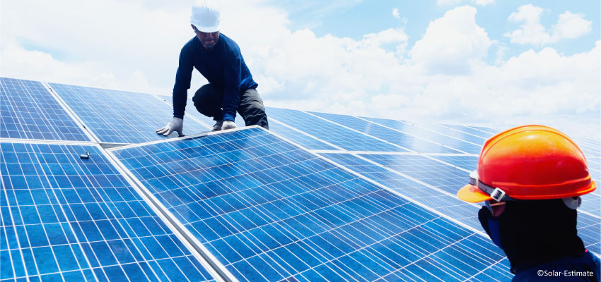 Two men installing solar panels