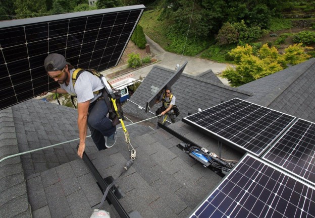 a solar installer on top of a roof