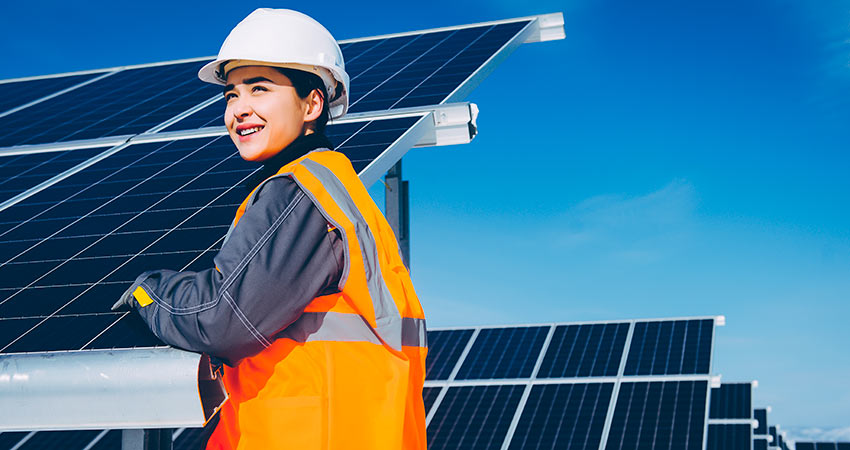 Technician standing in front of solar panels